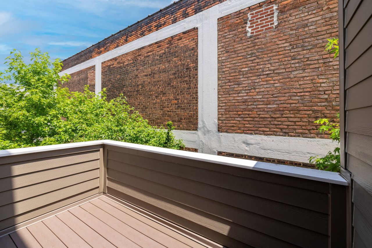 A wooden deck with a brick wall in the background.