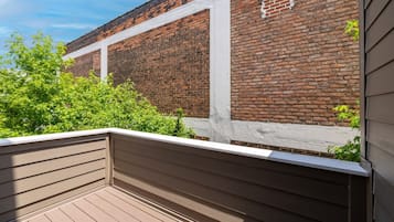 A wooden deck with a brick wall in the background.