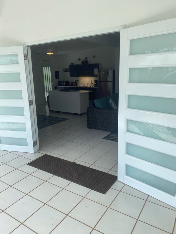 Una cocina moderna con una isla central, un refrigerador y un comedor con sofá.