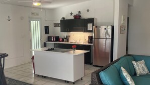 A spacious living area with a kitchen, a dining table, and a sofa.