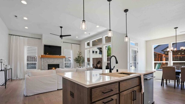 A modern kitchen with a central island, pendant lighting, and a dining area with a view. - Prestine and Comfortable Home (Brush Prairie)