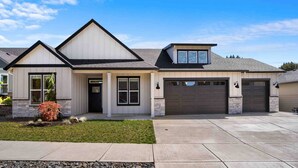 A modern two-story house with a garage, a front porch, and a well-maintained lawn. - Prestine and Comfortable Home (Brush Prairie)