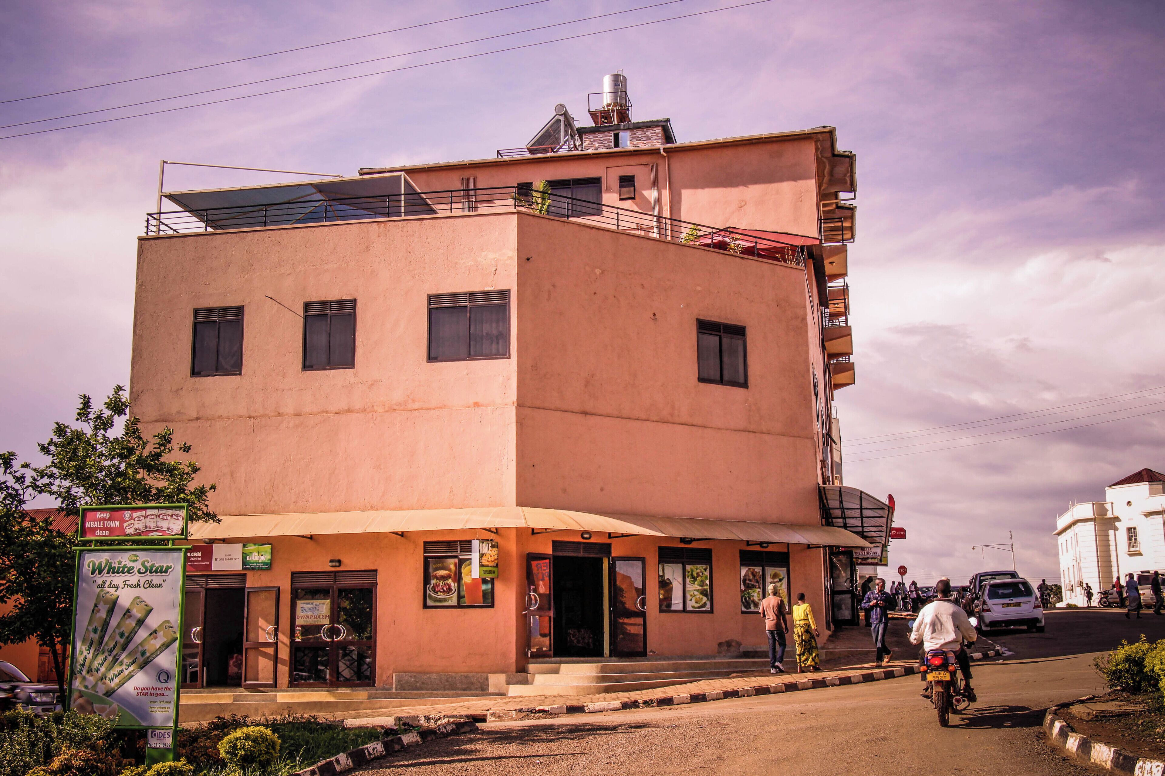 A multi-story building with a ground-level restaurant, a visible staircase, and a satellite dish on the roof.