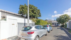 Une rue résidentielle bordée de voitures garées et de maisons.