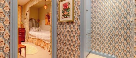 A bedroom with a bed, a dresser, and a mirror.