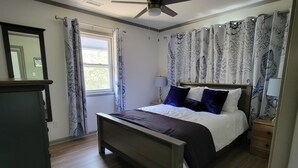 A bedroom with a bed, a ceiling fan, a window with curtains, and a dresser. - Something for everyone! Walk to beach/restaurant/parks/
shopping/entertainment (Nags Head)