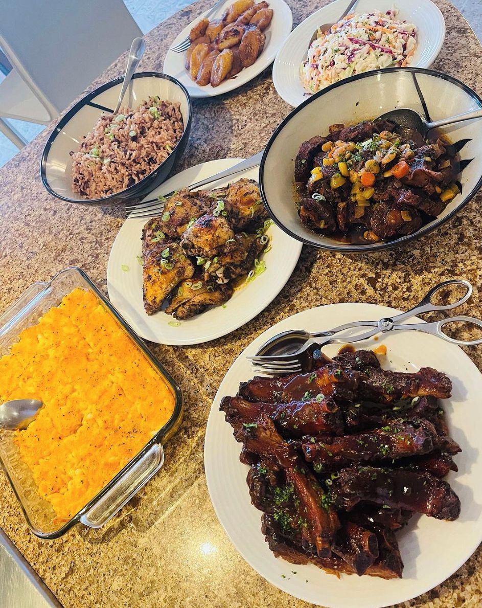 Une table à manger avec différents plats, notamment du riz, une salade de chou et un gratin.