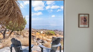 Een kamer met twee Adirondack-stoelen gericht op een grote schuifdeur.