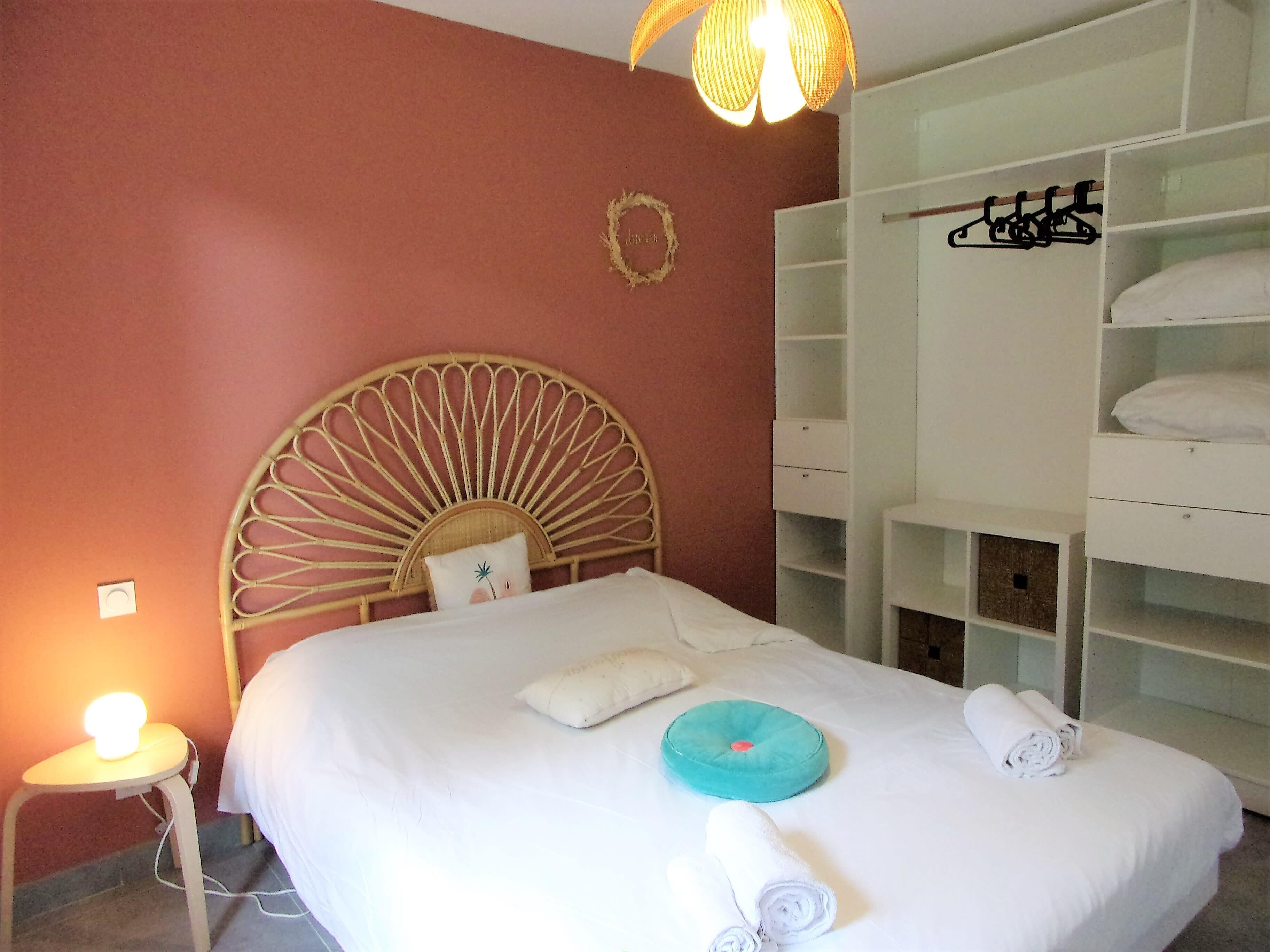 Une chambre d’hôtel comprenant un lit, une table de chevet avec une lampe, une armoire et un porte-serviettes fixé au mur.