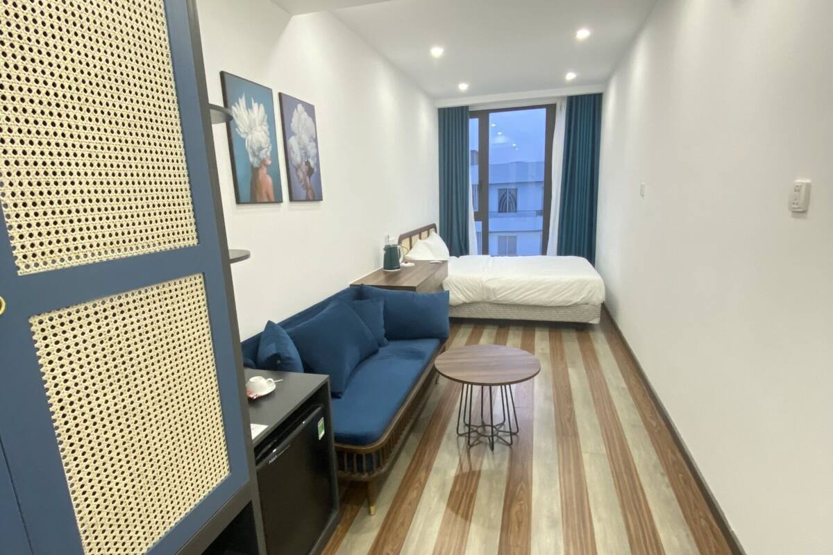 Ein modernes Hotelzimmer mit einer Couch, einem kleinen Tisch, einer Lampe und einem Bett.