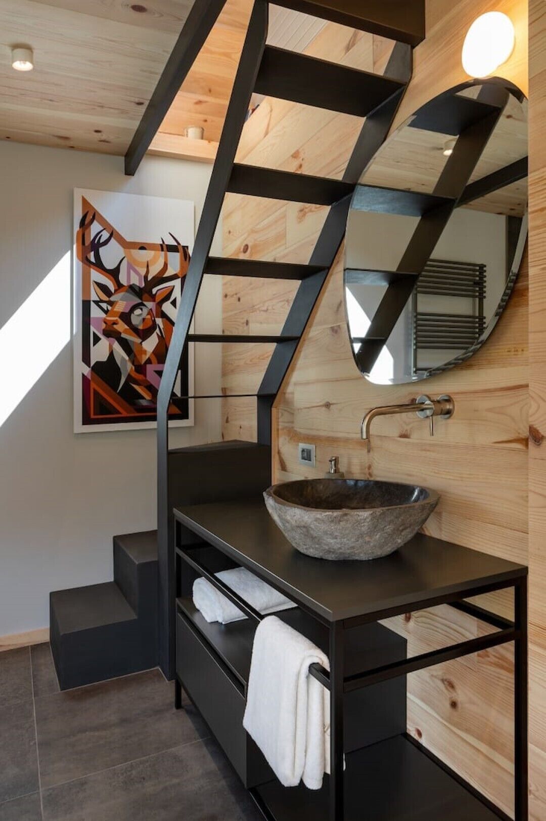 Une salle de bain moderne avec un meuble-lavabo en bois, un grand miroir et un plafond au design géométrique original.
