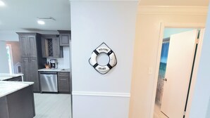 Eine moderne Küche mit grauen Schränken, einem Edelstahlkühlschrank und einer Kaffeemaschine auf der Arbeitsfläche.