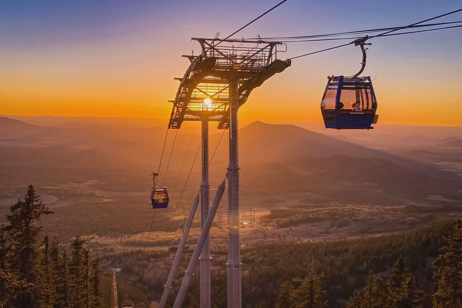 Sistema de teleférico con vistas despejadas del paisaje montañoso circundante al atardecer.