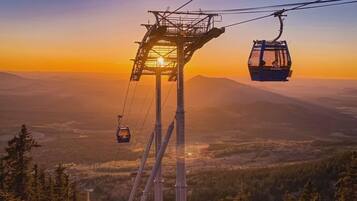 Sistema de teleférico con vistas despejadas del paisaje montañoso circundante al atardecer.