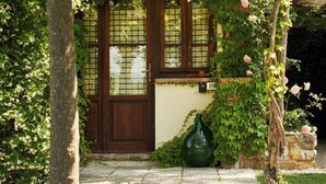 A traditional Japanese-style entrance with a wooden door, a stone pathway, and a green vase. - La Vignaccia the Old Barn - Villa W Private Pool (Pergine Valdarno)