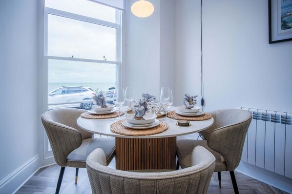 Enjoy meals with family and friends at this dining area, featuring a round table for four and comfortable seating.