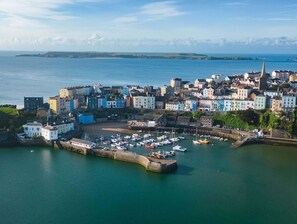 Experience the charm of a bustling coastal town with a vibrant harbor, surrounded by natural landscapes and a mix of traditional and modern architecture.