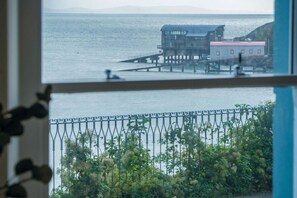 Enjoy the serene coastal views from this building's interior, overlooking a tranquil body of water and a picturesque pier.