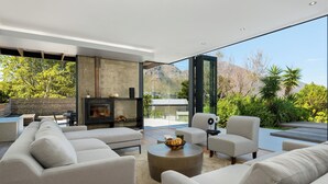 Ein modernes Wohnzimmer mit einer großen Sofagarnitur, einem runden Couchtisch und einem Kamin.