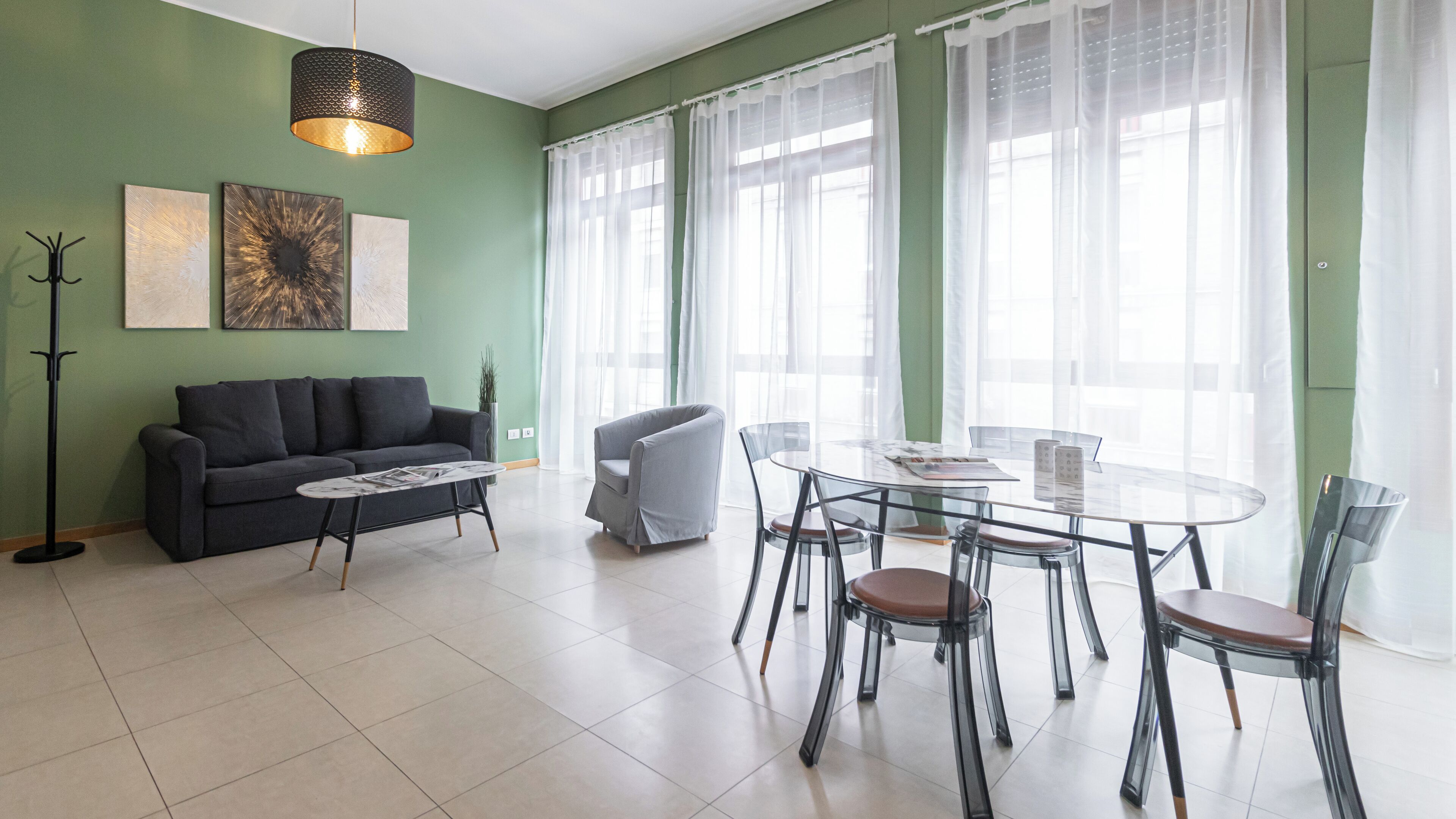 A modern living room with a sofa, a coffee table, and a dining table with chairs.