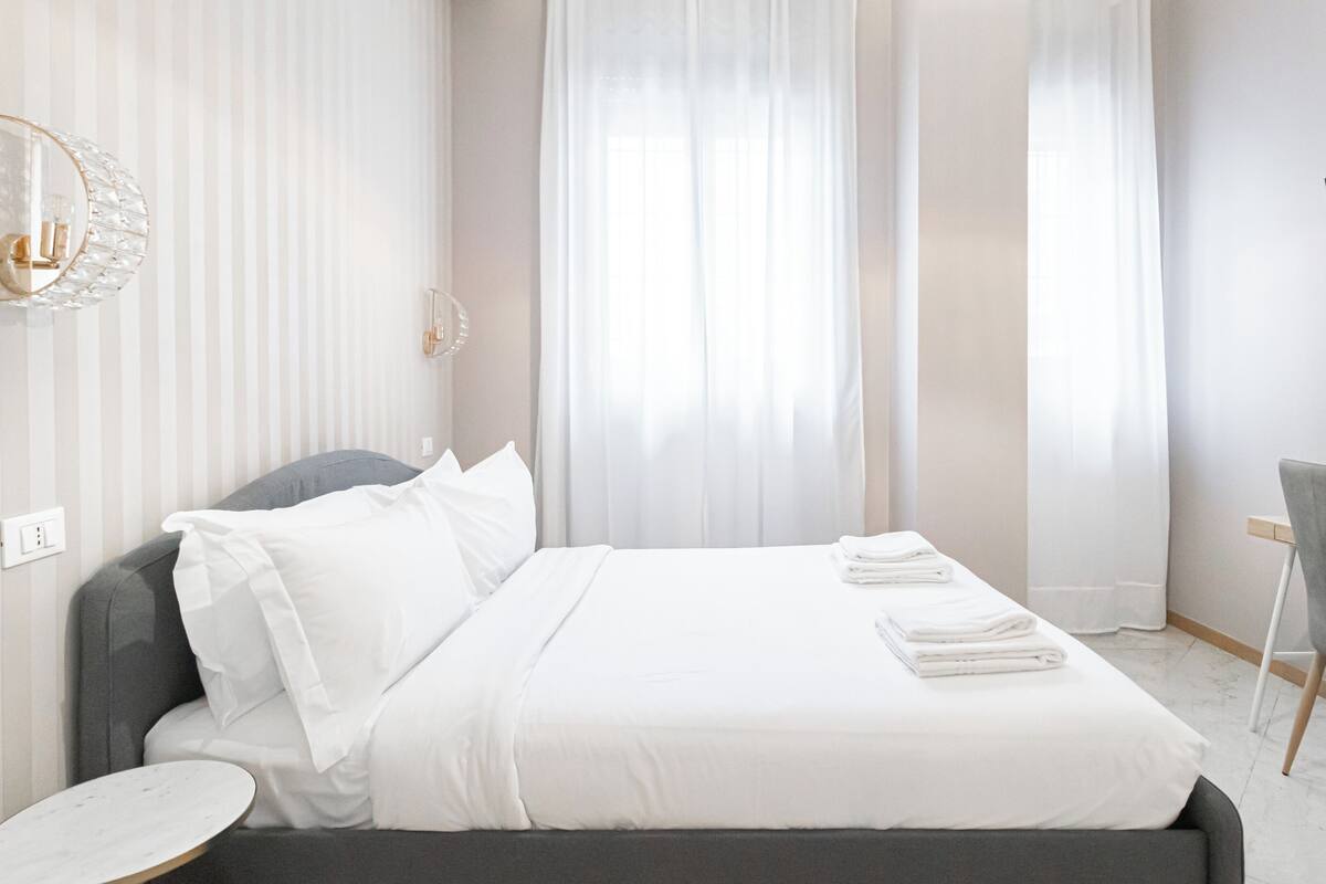 Ein Hotelzimmer mit Bett, Schreibtisch, Stuhl und Fernseher.