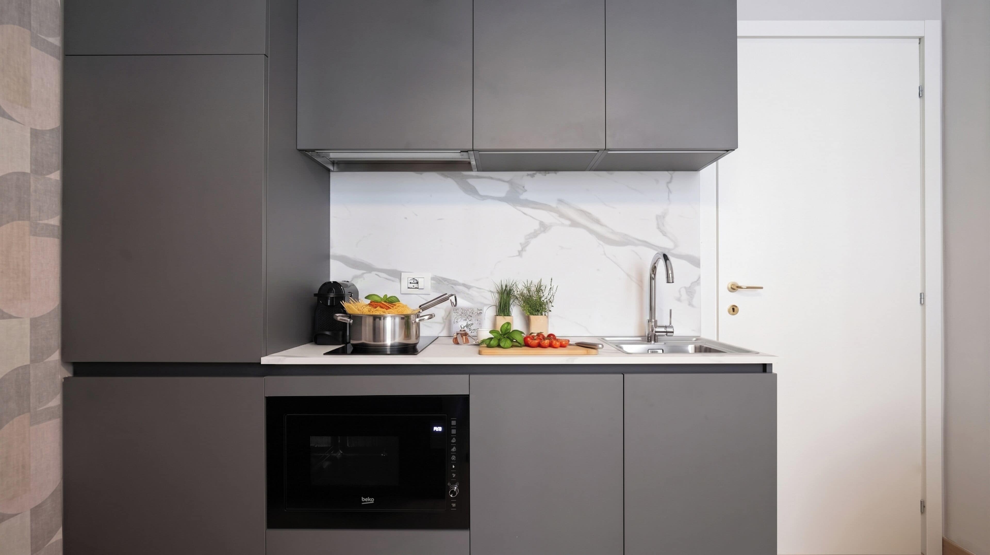 A modern kitchen with a built-in oven, a sink, and a stove.