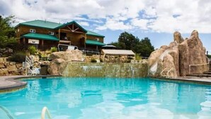 A pool area with a wooden building in the background. - Zion Views- Kolob Cabin + Resort Access (Orderville)