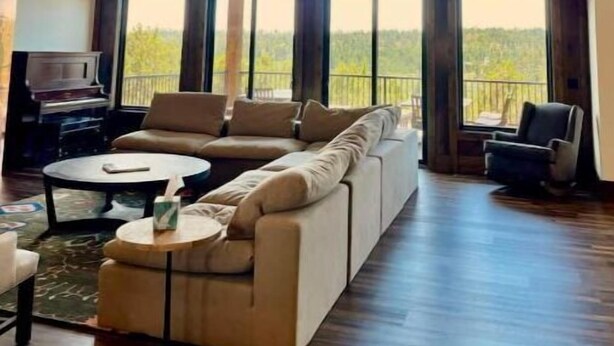 A spacious living room with a large sectional sofa, a piano, and a television. - Zion Views- Kolob Cabin + Resort Access (Orderville)