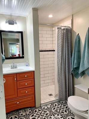 A bathroom with a white sink, wooden vanity, a shower with a glass door, and a toilet. - Downtown Birdie / walk to whiskey row (Prescott)