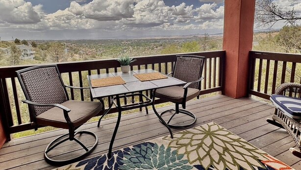 A wooden deck with a table and two chairs, overlooking a landscape. - Comfy Mountain Side Stay - Incredible Views (Prescott)