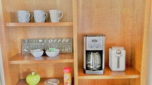 A wooden shelf with white cups, a coffee maker, a teapot, and a sign that reads "Cup of Coffee Shared Friends & Happiness Tasted and Scented." - Comfy Mountain Side Stay - Incredible Views (Prescott)