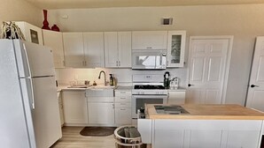 A compact kitchen with white cabinets, a stainless steel trash can, and a wooden countertop. - Comfy Mountain Side Stay - Incredible Views (Prescott)