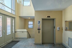 A hallway with a door, a window, and a sign on the wall.