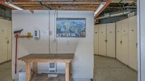Ein Hauswirtschaftsraum mit Holztisch, Besen, Mülleimer und einem SilverStar-Poster an der Wand.