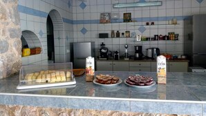 A kitchen with a marble countertop displaying various food items and a refrigerator. - fira Blue Horizon (Santorini)