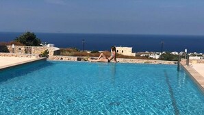 A clear blue pool with a view of the sea and buildings in the background. - fira Blue Horizon (Santorini)