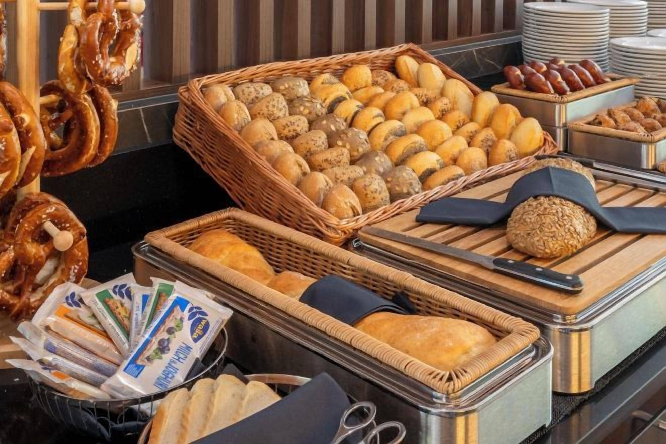 Un bufé con diversas opciones de panadería, como pretzels y pan.