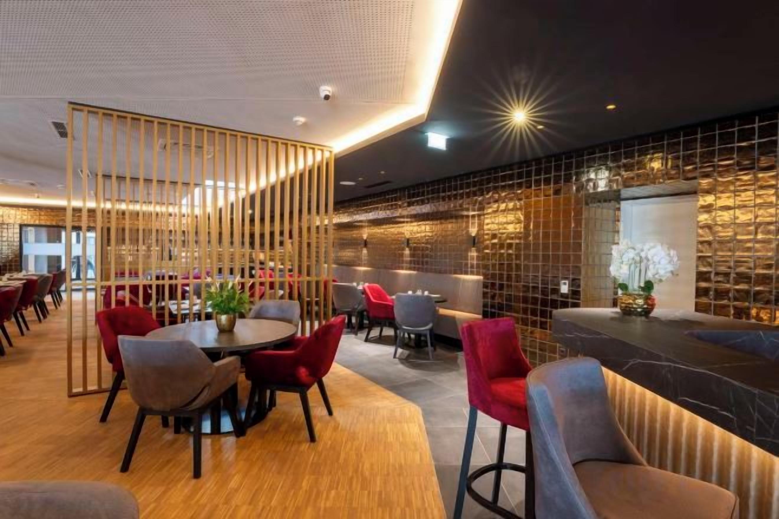 A modern interior with a bar area, seating arrangements, and a decorative partition.