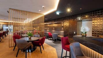 A modern interior with a bar area, seating arrangements, and a decorative partition.