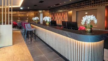 A reception area with a curved counter, seating, and decorative plants.