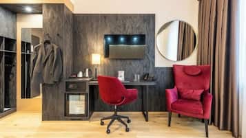 Quarto moderno com escrivaninha, duas cadeiras, televisão e guarda-roupa.