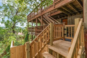 Una scala in legno conduce a un pontile con vista su un paesaggio verde e rigoglioso.