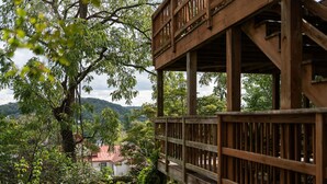 Une terrasse en bois offrant une vue sur une maison et la végétation environnante.