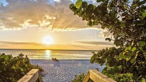 A sunset view over a body of water with a wooden structure in the foreground. - 677 Beach Break ·Beautiful 3/3 Home w/ Heated Pool (Naples)