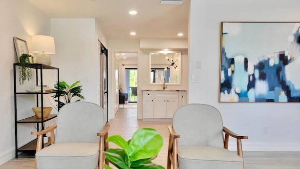 A modern living room with two armchairs, a coffee table, and a potted plant. - 835 Villas of GulfShore | Walk 2 Mercato & Beaches (Naples)