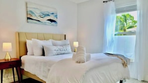 A neatly made bed with white bedding, a headboard, and a bedside lamp on each side. - 835 Villas of GulfShore | Walk 2 Mercato & Beaches (Naples)