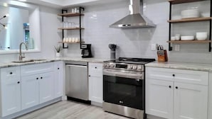 A modern kitchen with white cabinets, a stainless steel stove, and a built-in oven. - 835 Villas of GulfShore | Walk 2 Mercato & Beaches (Naples)