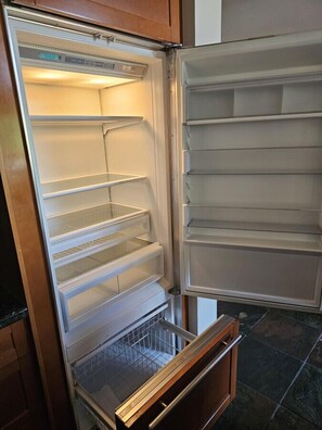An open refrigerator with multiple shelves and a freezer compartment.