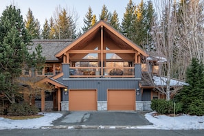 A two-story log cabin with a steep gable roof, large windows, and a garage. - Whistler Village North: 4BR+3.5BA Private Hot Tub (Whistler)