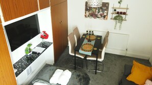 A compact living space with a kitchenette, dining area, and a sofa. - Stylish 2 Bed Room Apartment 3 Sleep Free Wifi & p (Newport)